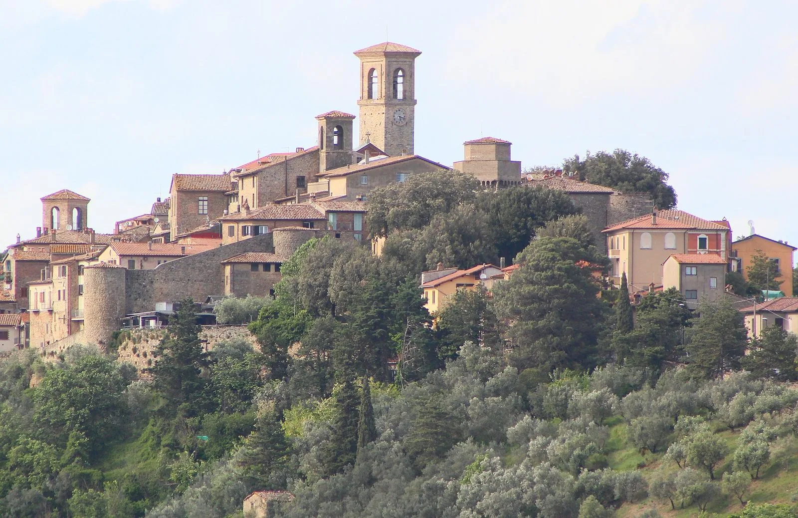Il borgo di Collazzone sulla sommità della collina, con campanili, mura e pendii coperti di ulivi